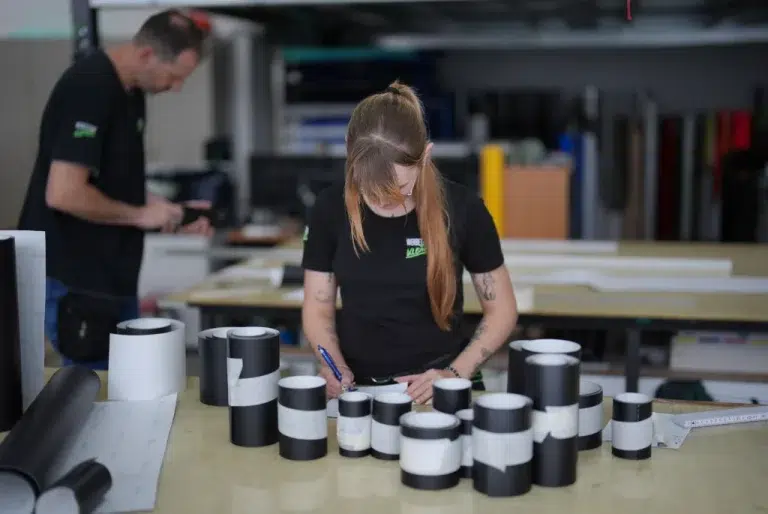 Manuelle Weiterverarbeitung und Qualitätskontrolle von Druckprodukten durch Mitarbeiter bei Werbetechnik Kleiner GmbH.