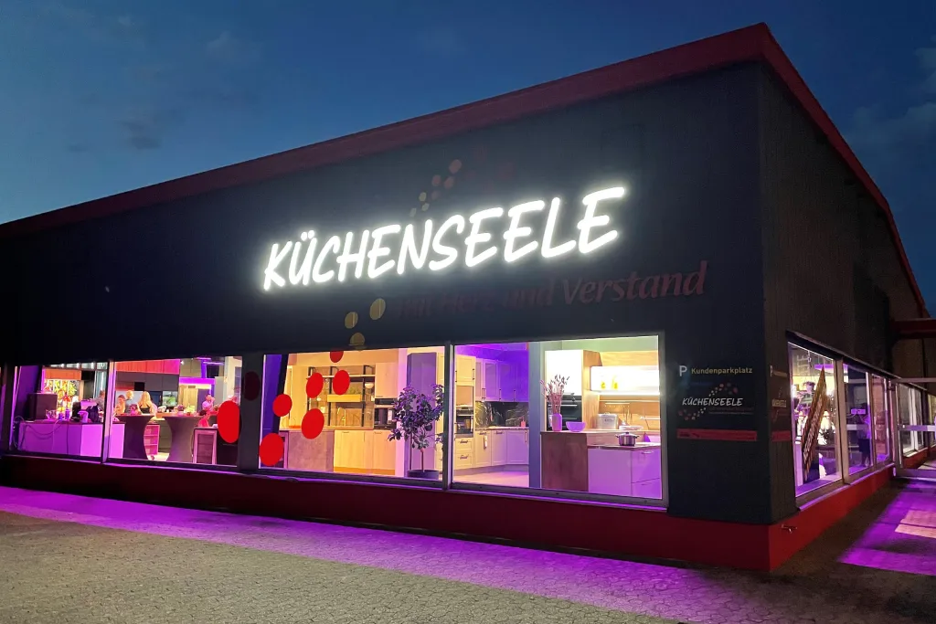 Beleuchtete Außenwerbung Küchenseele bei Nacht mit LED-Profilbuchstaben, realisiert durch Werbetechnik Kleiner GmbH