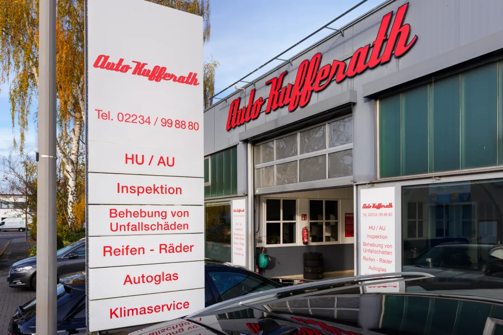 Fassadenbeschriftung Auto Kufferath mit roter Typografie und Leistungsübersicht, ausgeführt von Werbetechnik Kleiner GmbH