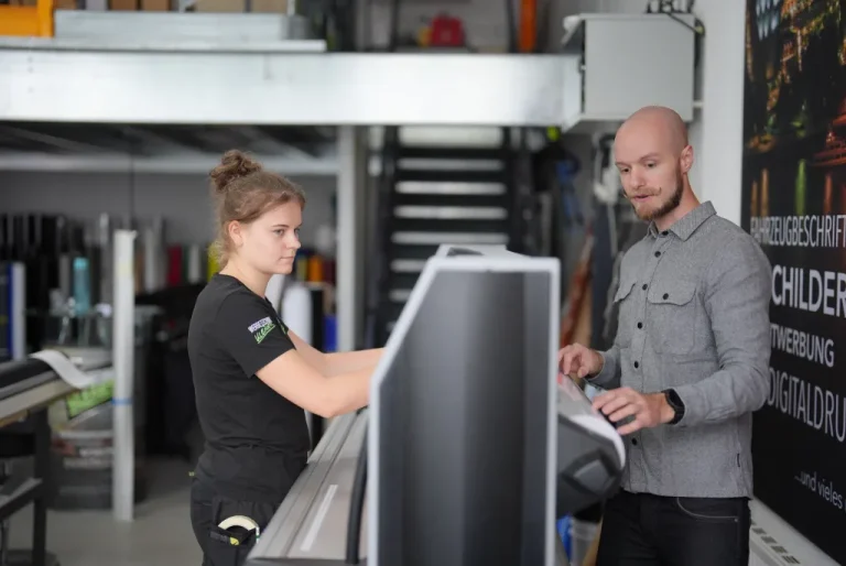 Teamarbeit bei der Montage und Vorbereitung einer Leuchtwerbeanlage in der Werkstatt von Werbetechnik Kleiner GmbH.
